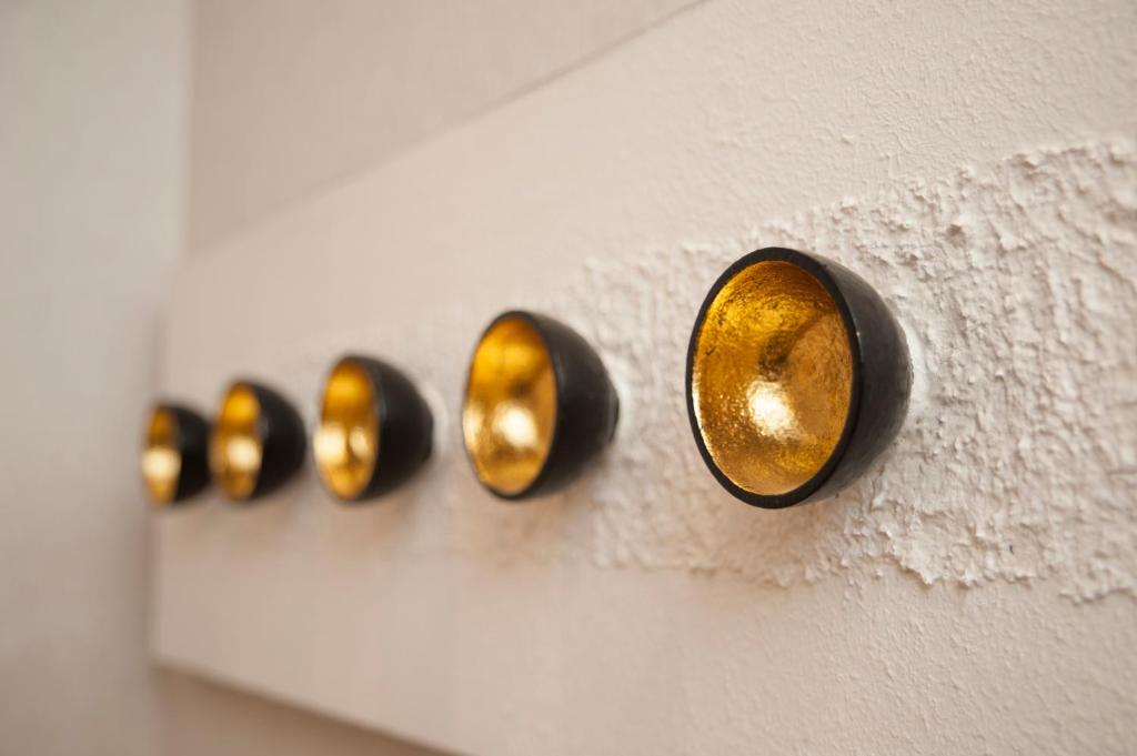 a row of gold knobs on a white wall at Yesday B&amp;B in Dongshan