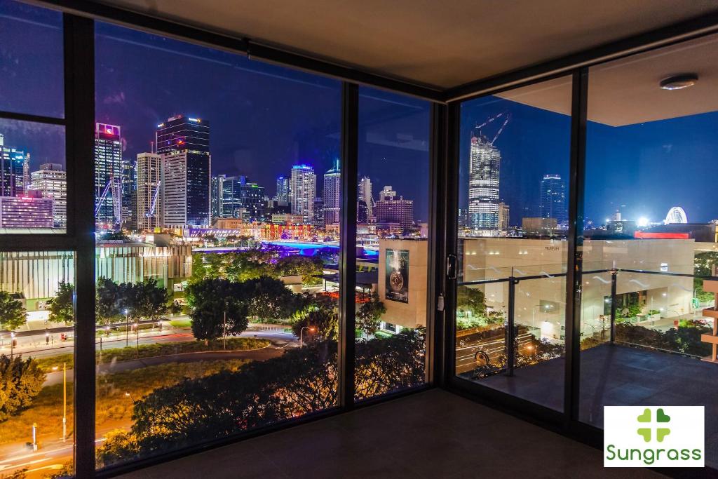 a room with a view of the city at night at Fleet Lane Apartments in Brisbane