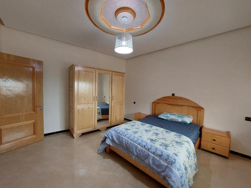 a bedroom with a bed and a chandelier at Cozy Al Hoceima Apt, Near Beach in Al Hoceïma