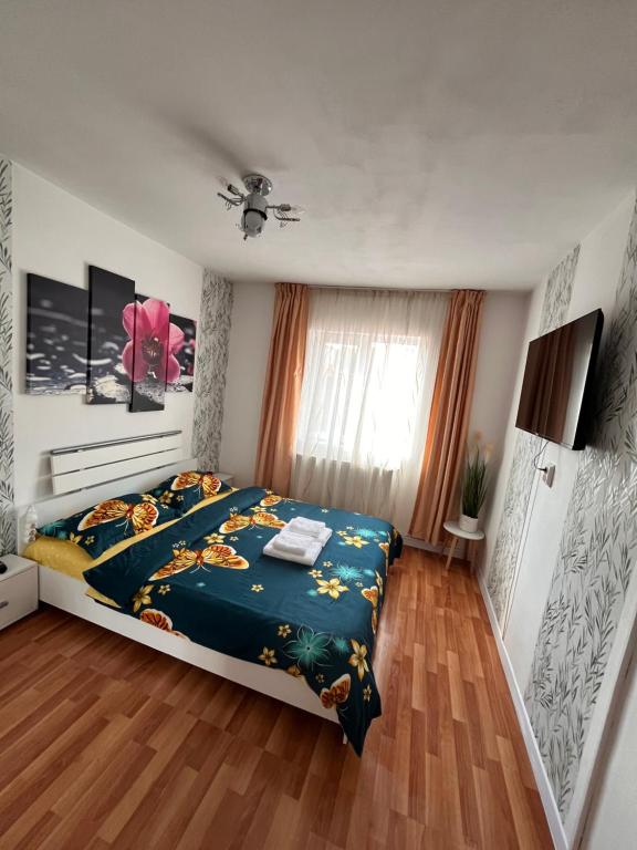 a bedroom with a bed with a blue comforter at Medeea 1 camera in Zalău