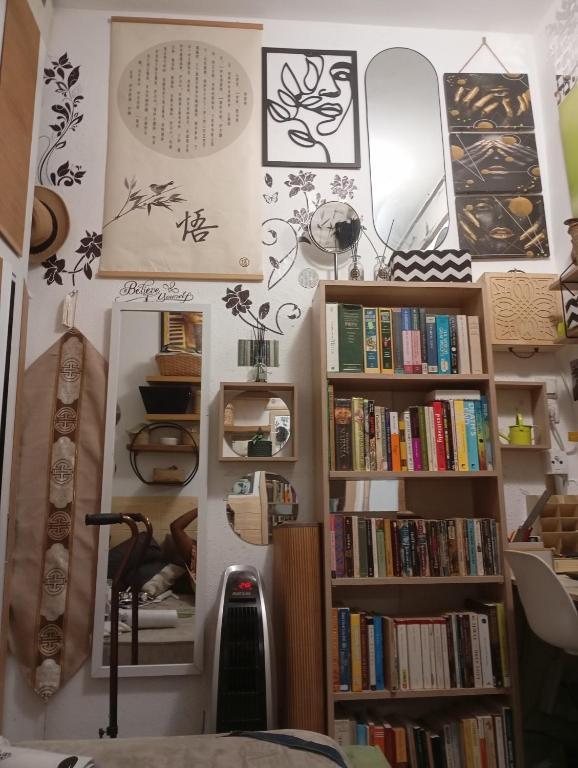 a room with bookshelves and a wall filled with books at Garden Apartment Bnai Brak in Bene Beraq