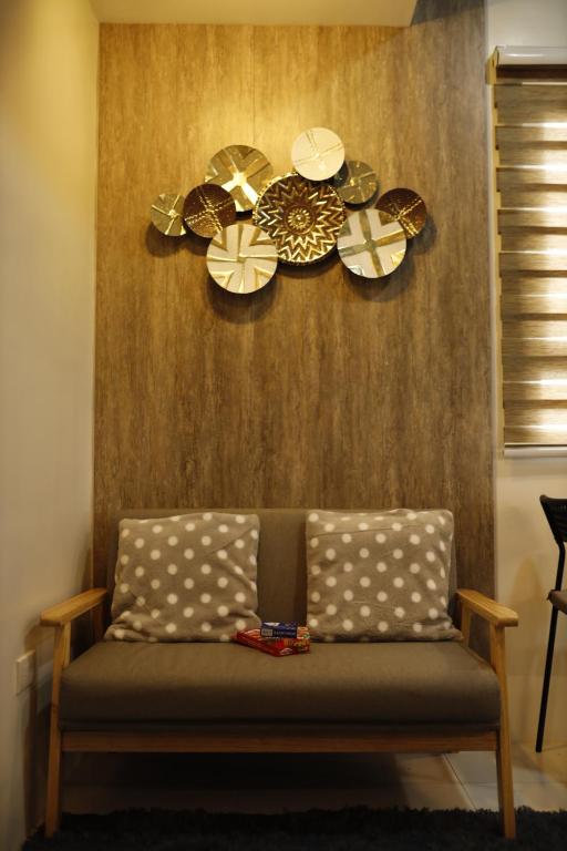 a couch in a room with plates on the wall at La Joya Suite in Naga