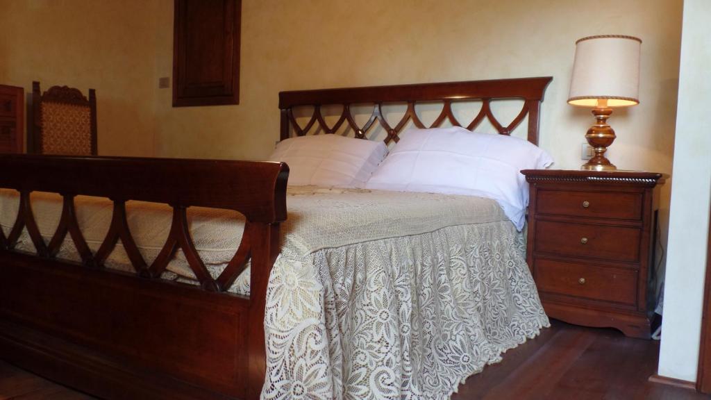 sypialnia z łóżkiem z białymi poduszkami i lampą w obiekcie Il Fienile Holiday Home w mieście Le Fornacette
