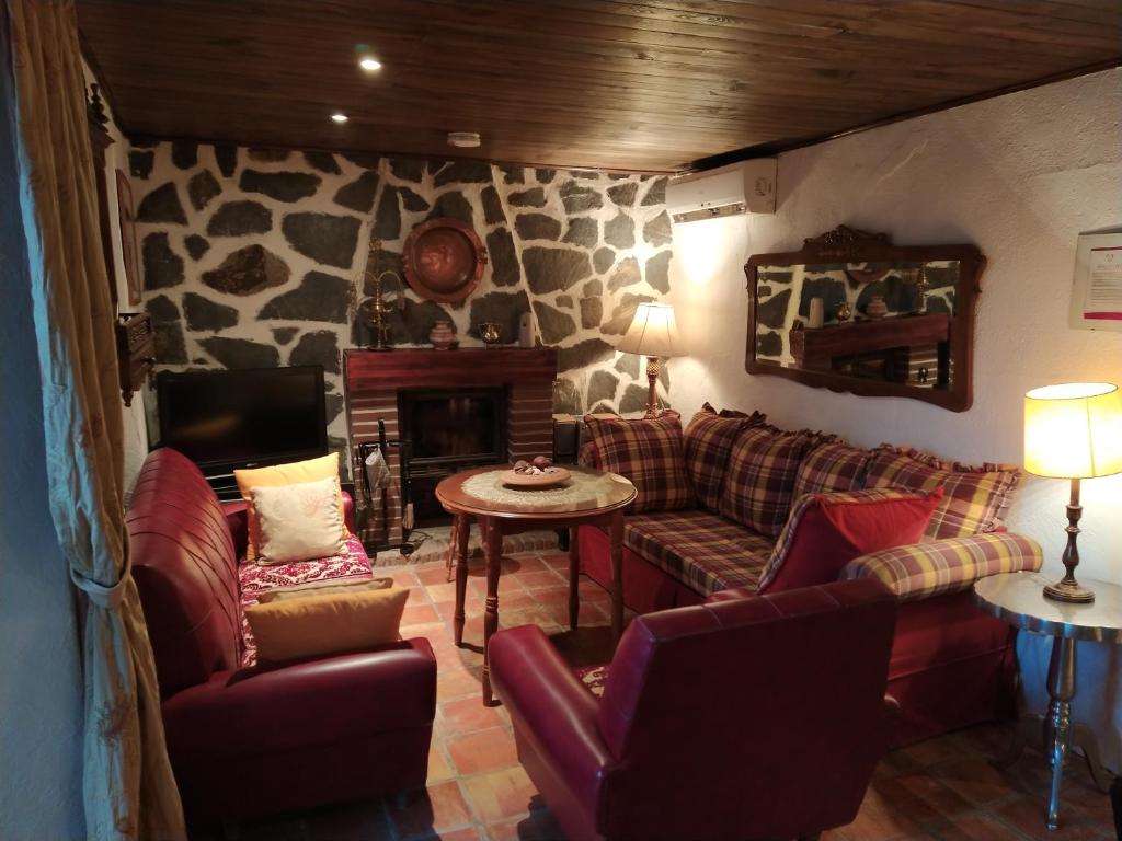 - un salon avec des canapés, une table et une cheminée dans l'établissement Mágina Dream Pegalajar Dormitorios disponibles según número huéspedes, à Pegalajar