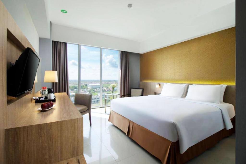 Postel nebo postele na pokoji v ubytování Grand Tan Banjarmasin Hotel & Convention Center