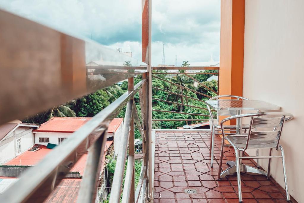 a balcony with a table and chair on a balcony at La Joya Suite in Naga