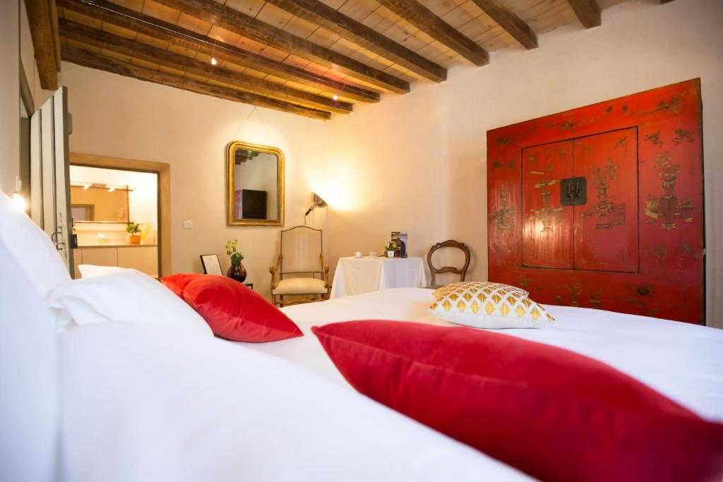 1 dormitorio con 1 cama blanca grande con almohadas rojas en Clos Saint Jacques - Maison d'Hôtes, en Meursault
