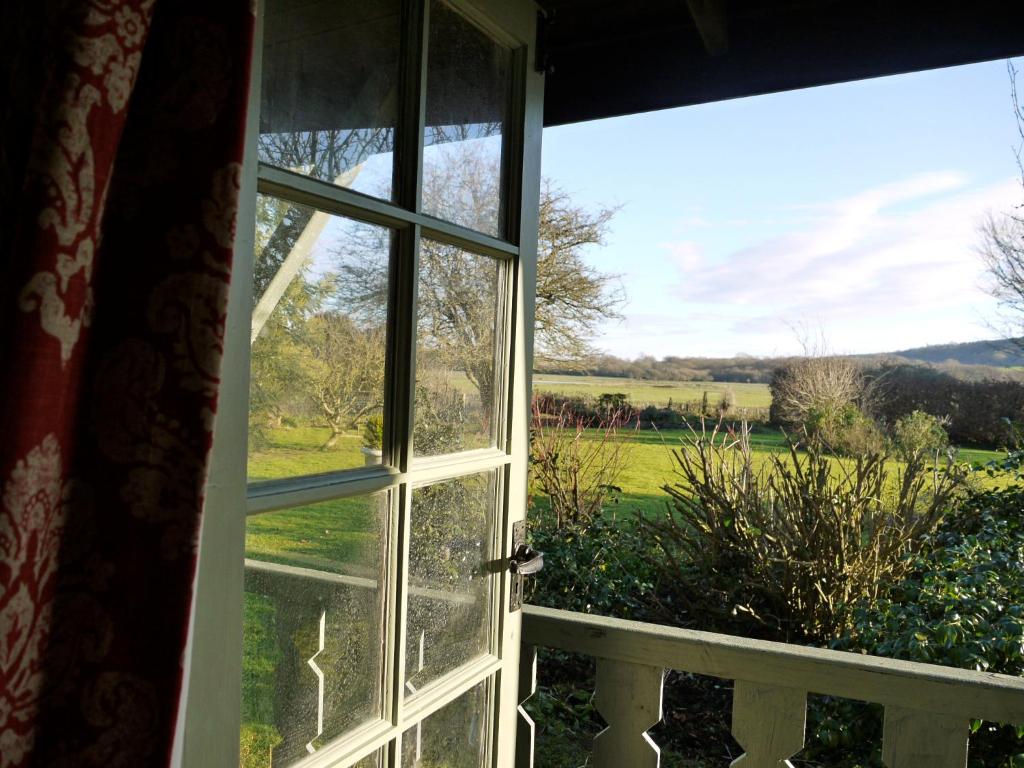 an open window with a view of a field at The Lodge On The Marsh in Brading