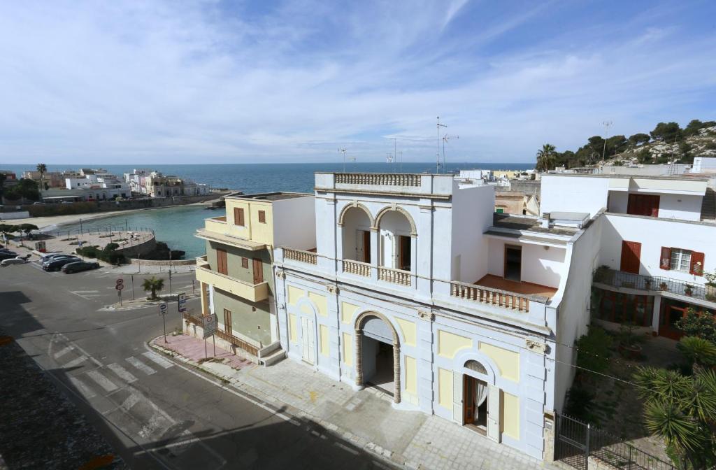 a building with the ocean in the background at Palazzo Stapane in Santa Maria al Bagno