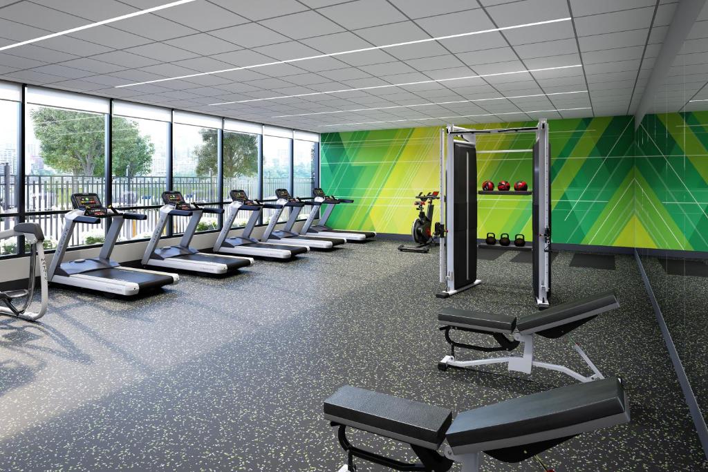 un gimnasio con una fila de cintas de correr y bancos en Holiday Inn Coralville - Iowa City by IHG, en Coralville