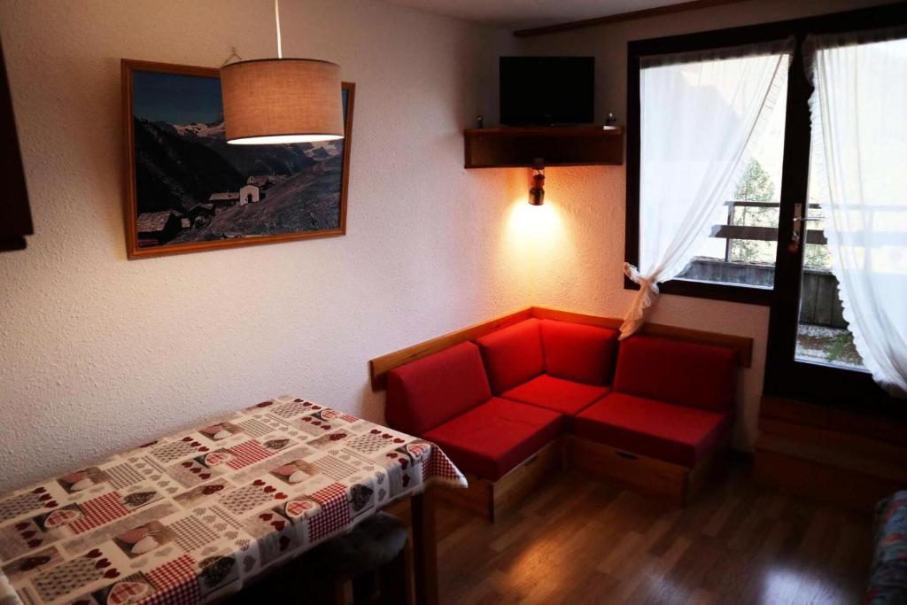 un salon avec un canapé rouge et une table dans l'établissement Résidence Le Cairn - STUDIO N° 0309 LE CAIRN MAE-4511, aux Orres