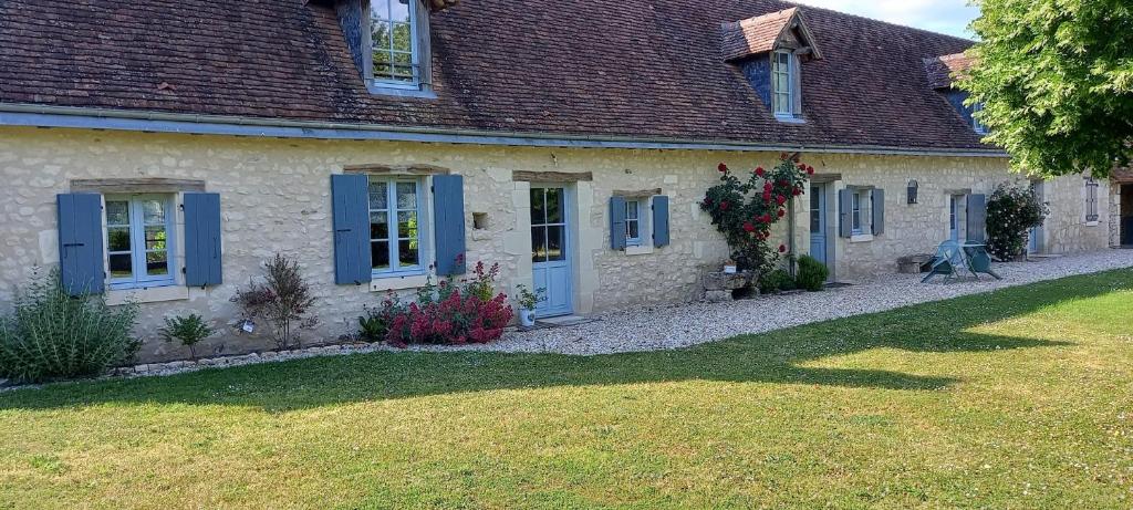 Casa de piedra con persianas azules y patio en La longère du golf, en Verneuil-sur-Indre