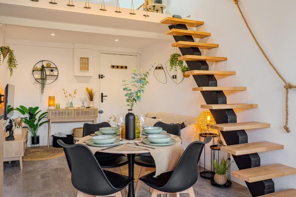 une salle à manger avec une table et un escalier en colimaçon dans l'établissement Casa Paillote - Sur le Port - Climatisation - Cosy, à Mauguio