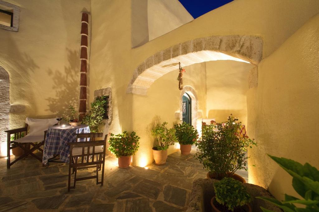 a patio with a table and chairs and potted plants at Abramis Rooms in Mitáta