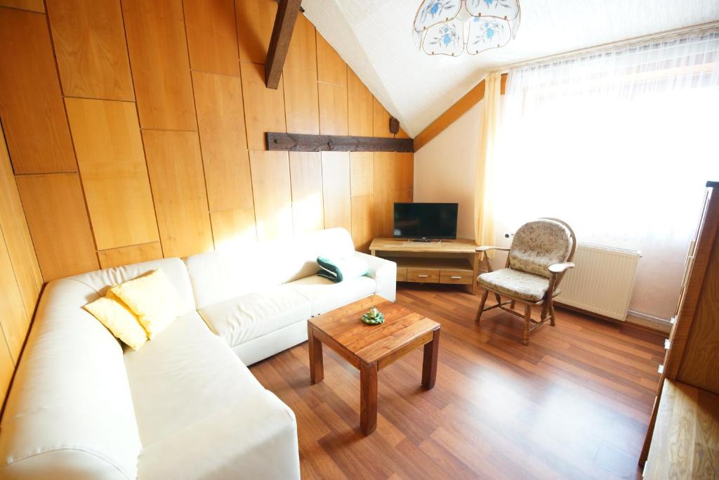 a living room with a white couch and a table at Pension Zum Froschkönig in Lübbenau