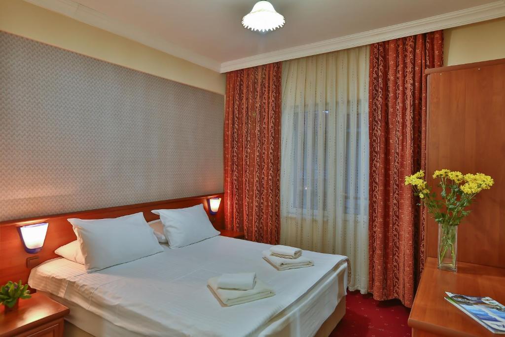 a hotel room with a bed and a vase of flowers at Afyon Dundar Thermal Villa in Afyon