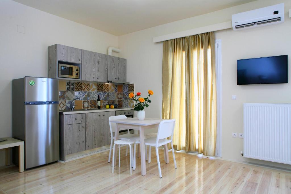 een keuken met een tafel en stoelen en een koelkast bij Niriides in Lefkada