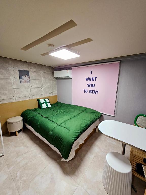 a room with a green bed with a sign on the wall at Space Stay in Seoul