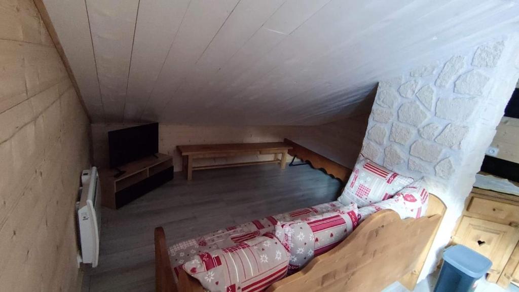 Cette chambre dispose d'un canapé et d'une télévision. dans l'établissement Gîte des flocons, à Morbier
