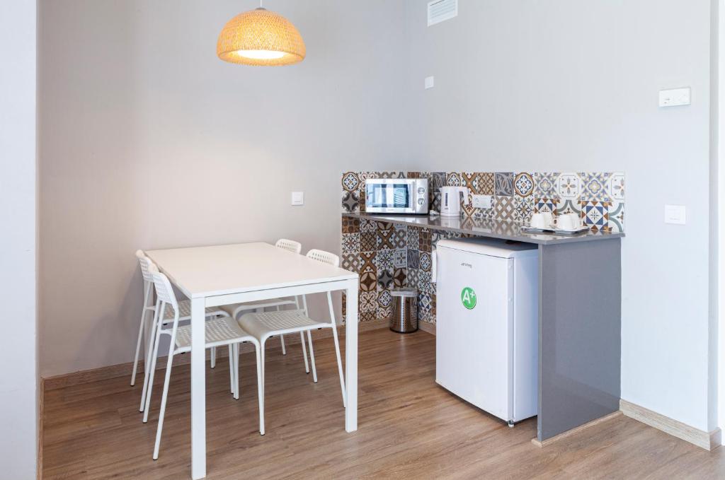 a kitchen with a white table and chairs and a refrigerator at Minura Sur Menorca in Punta Prima