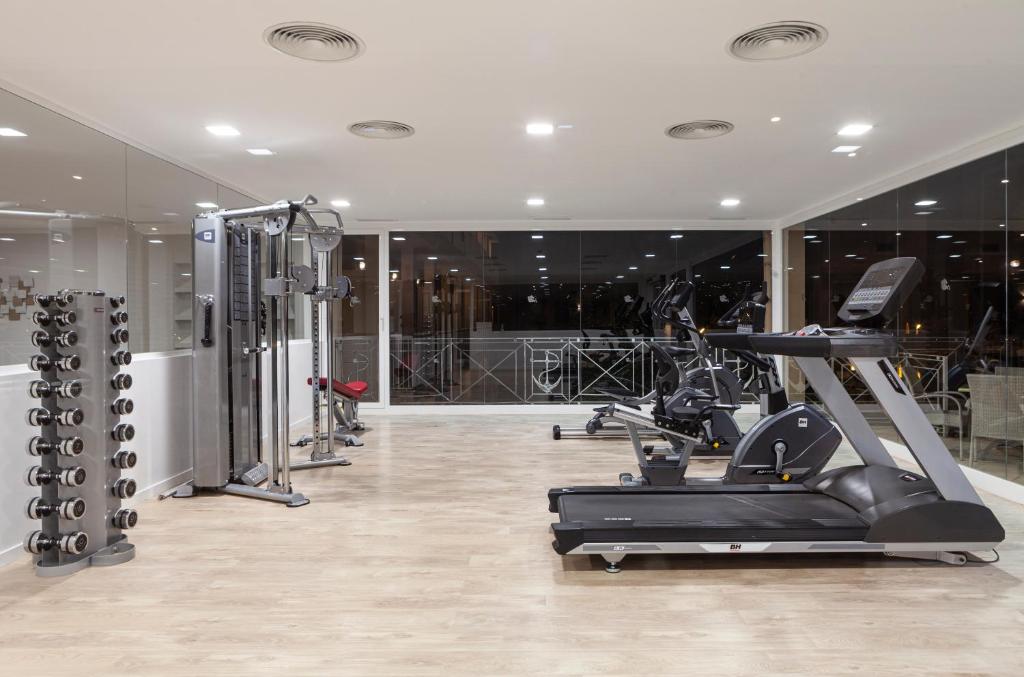 a gym with a treadmill and a elliptical machine at Minura Sur Menorca in Punta Prima