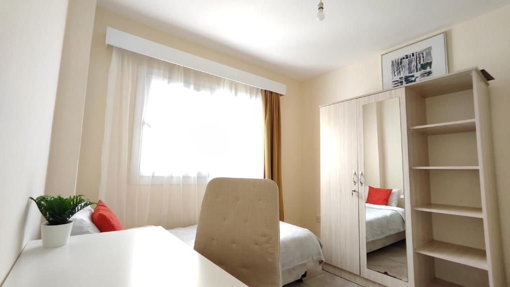 a white room with a window and a chair at VARIS Apartments 3BR in Kérynia