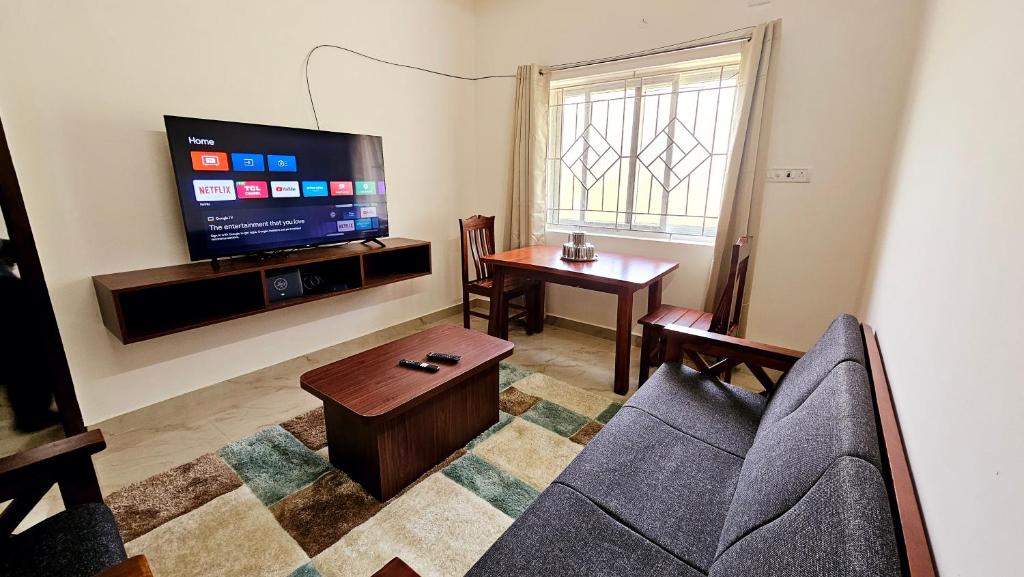 a living room with a couch and a flat screen tv at Chippy Service Apartments OMR No10 in Chennai