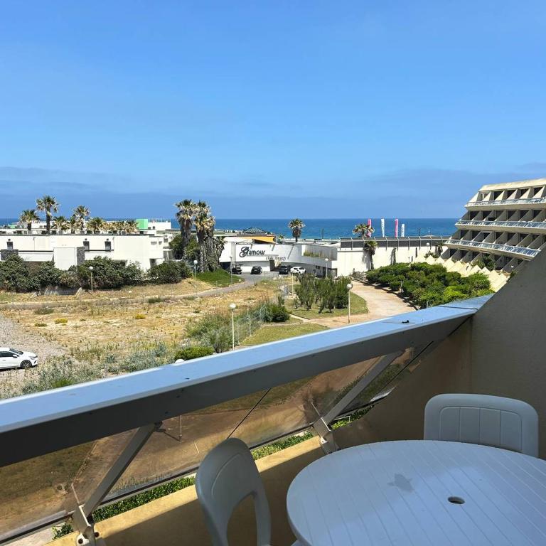 un balcon avec une table et des chaises et une vue sur l'océan dans l'établissement Studio Héliopolis E 27 - 2 personnes, au Cap d'Agde
