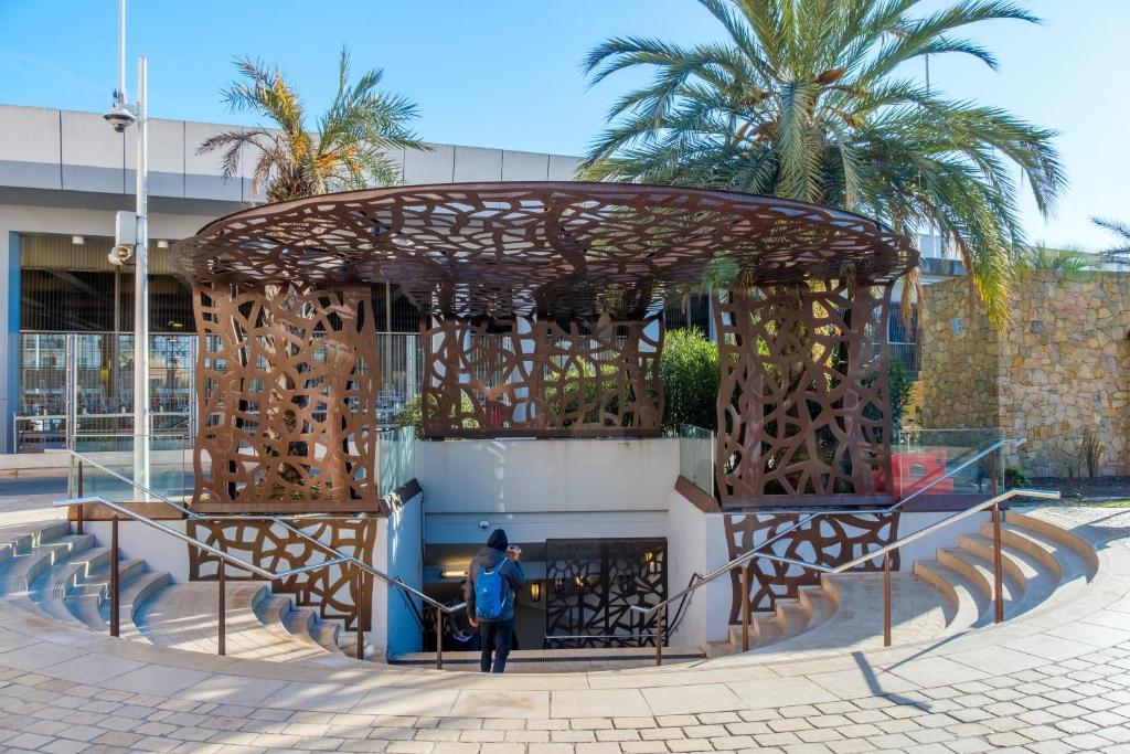 une femme se tient devant un bâtiment dans l'établissement Appartement Rooftop Centre Ville, à Cannes