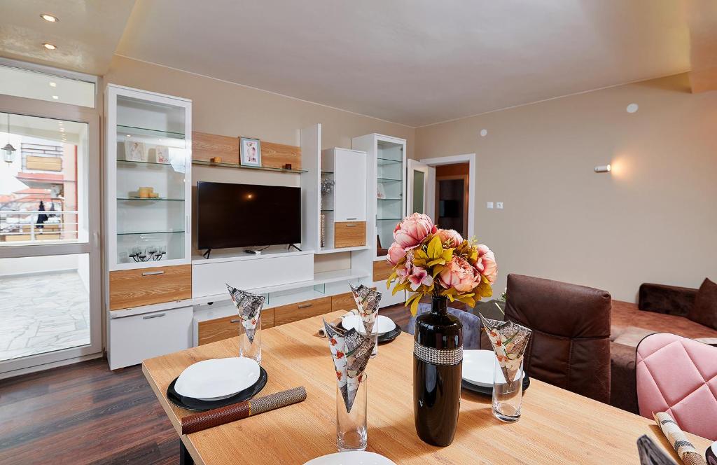 a living room with a table with a vase of flowers at Luxury Apartment Saint George Beauty and Style in Sveti Vlas