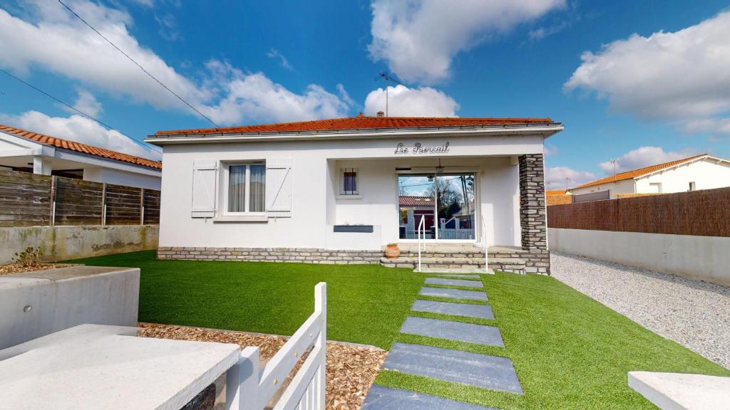une maison blanche avec une pelouse devant dans l'établissement Villa le Bercail, à Saint-Gilles-Croix-de-Vie