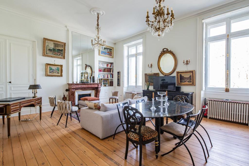 un salon avec une table et un canapé dans l'établissement Élégance et Luxe au Cœur de Bordeaux-Quinconces, à Bordeaux