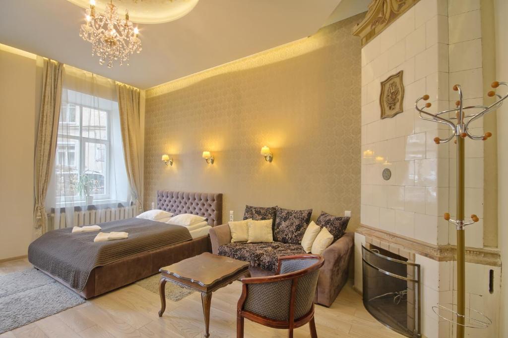 1 dormitorio con cama, sofá y mesa en Taurus Apartments Vilnius, en Vilna