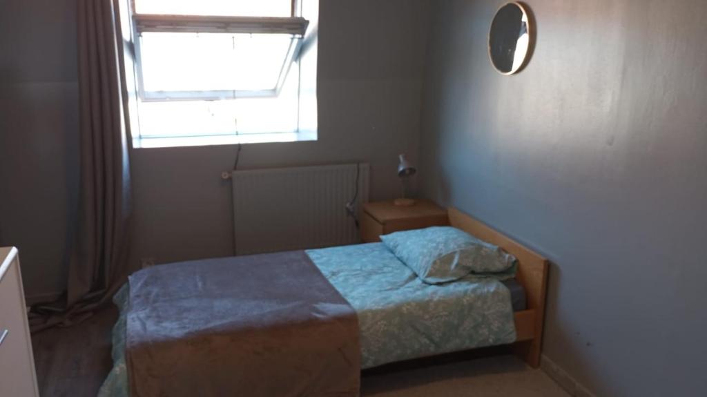 une petite chambre avec un lit et une fenêtre dans l'établissement Chambre Green, à Dunkerque