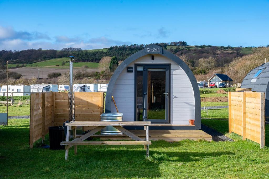 a small shed with a table in the grass at Wyke Lodges - Pod 2 in Guisborough