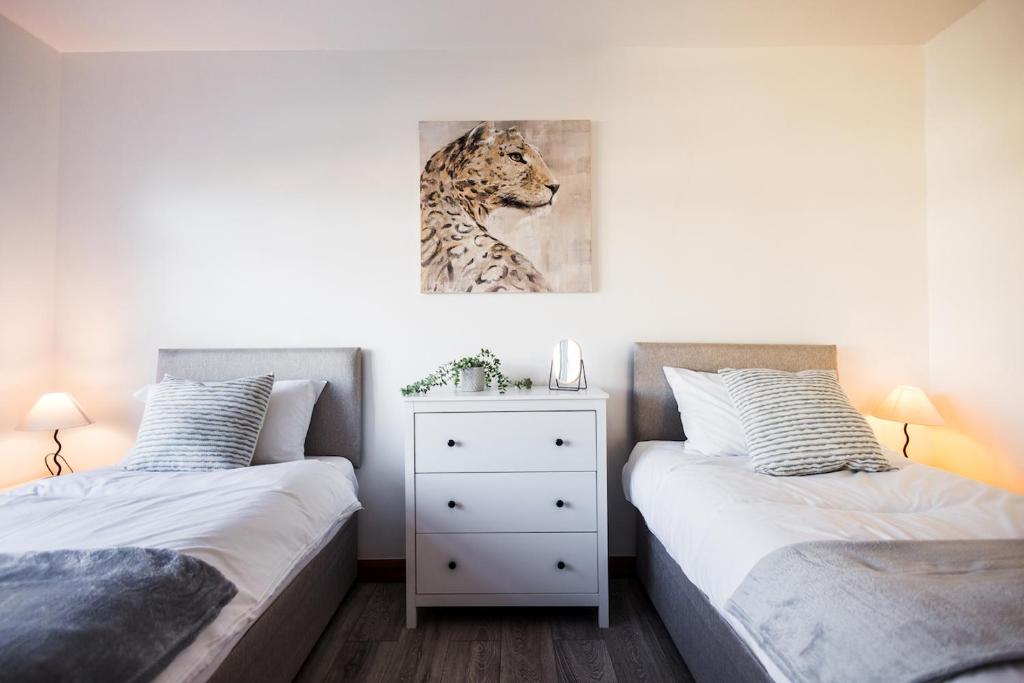 a bedroom with two beds and a painting of a leopard at Spacious 4 Bed with Free Parking in Southampton