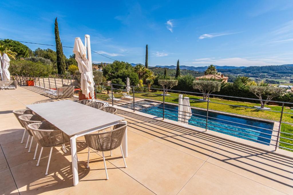 un patio avec une table et des chaises et une piscine dans l'établissement La Lauves, à Laouque