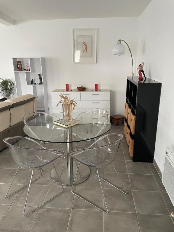 une salle à manger avec une table en verre et deux chaises dans l'établissement Maison agréable de 51 m2, à Cuts