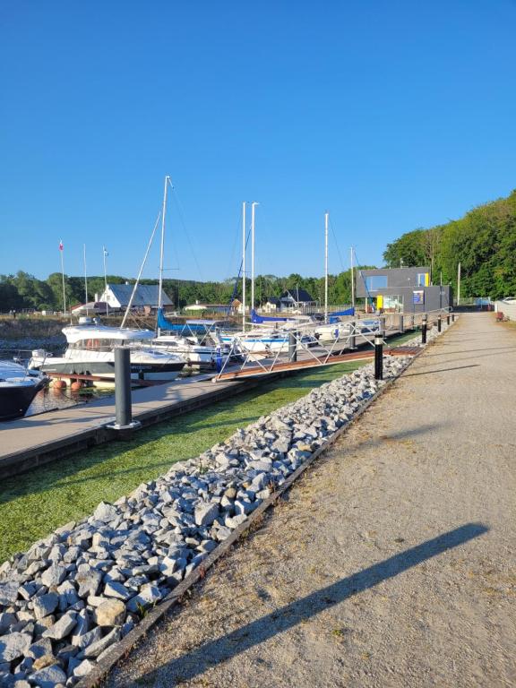 a row of rocks next to a marina with boats at Chatki przy Marinie in Wapnica