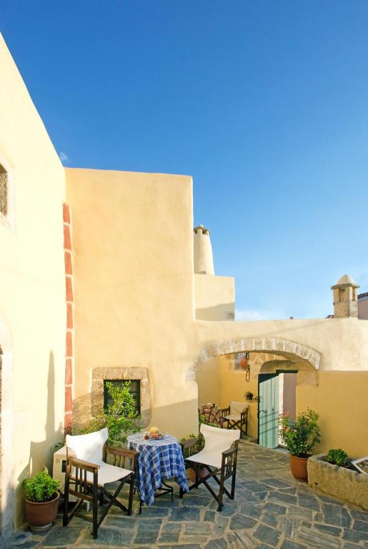 a patio with chairs and a table and a fireplace at Abramis Rooms in Mitáta