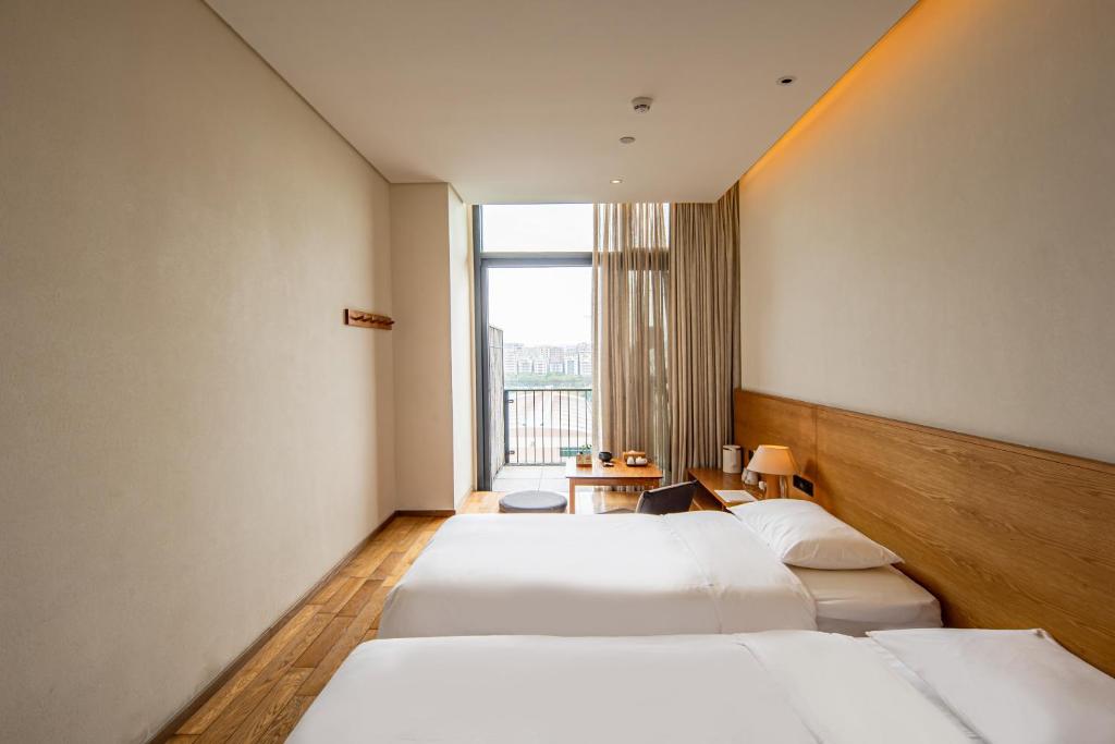 Postel nebo postele na pokoji v ubytování Taihua Wutong Hotel