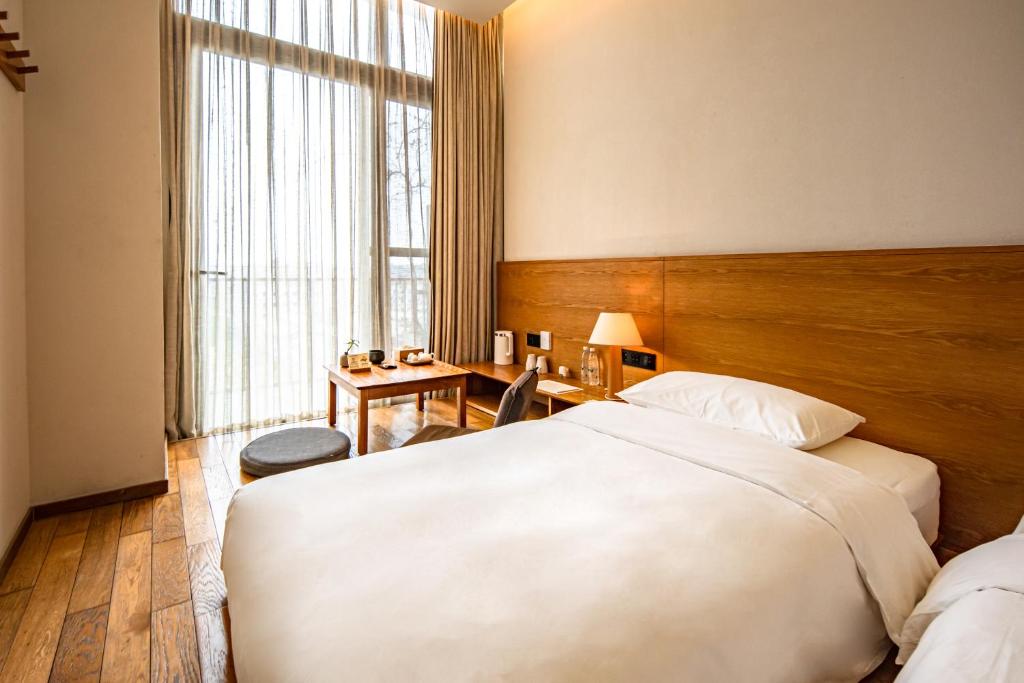 Postel nebo postele na pokoji v ubytování Taihua Wutong Hotel