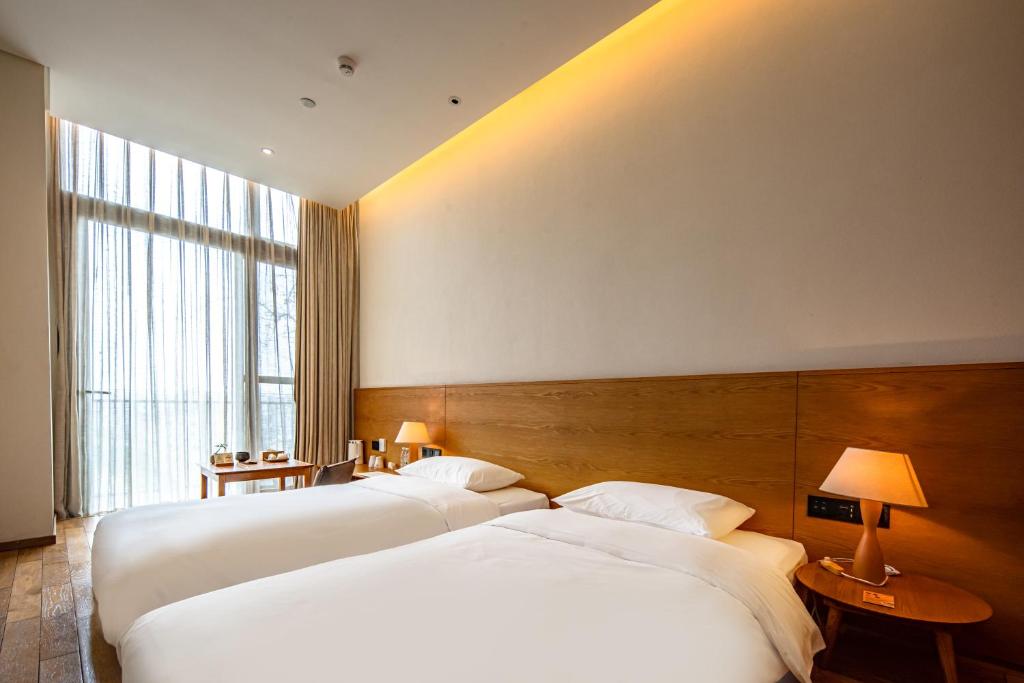 Postel nebo postele na pokoji v ubytování Taihua Wutong Hotel