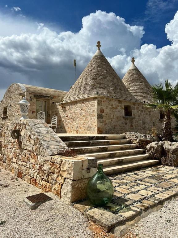 a stone building with a vase in front of it at Trulli San Pietro in Putignano