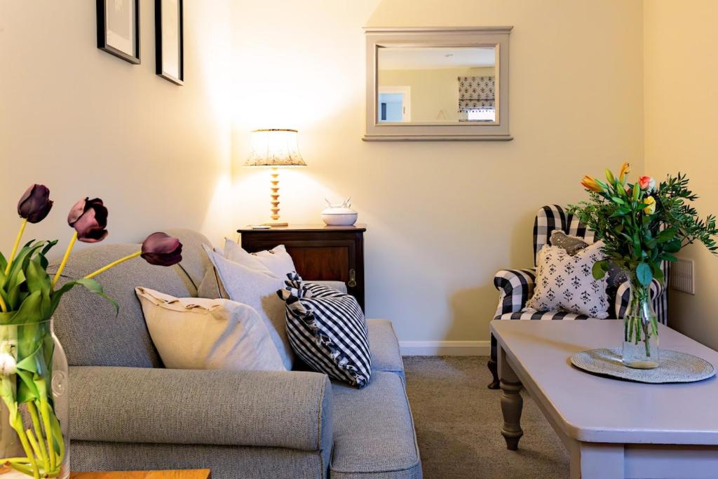 a living room with a couch and a table at Acorn Cottage in Quorndon