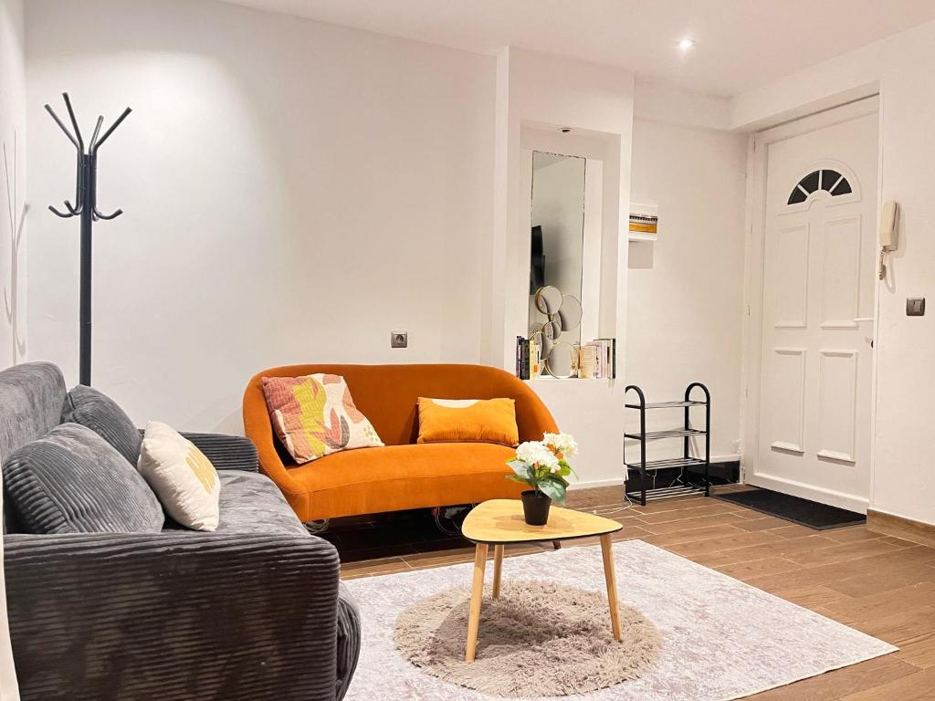 un salon avec un canapé et une table dans l'établissement Appartement à mi chemin entre aéroport et centre ville - Vue sur les montagnes - Echappée Belle, à Perpignan