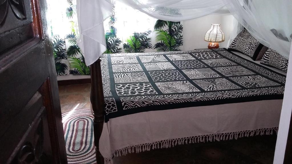 Villa Fortuna Malindi في ماليندي: غرفة نوم بسرير مع مظلة
