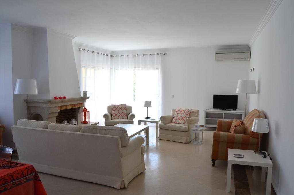 sala de estar con sofás, sillas y chimenea en Alegre Apartamento, en Cascais