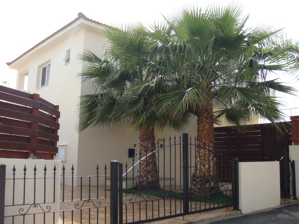 two palm trees in front of a house at Athena Villa in Ayia Napa