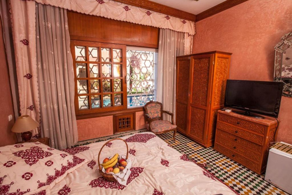 una camera da letto con un letto e un cesto di frutta; di Riad Alhambra a El Harhoura